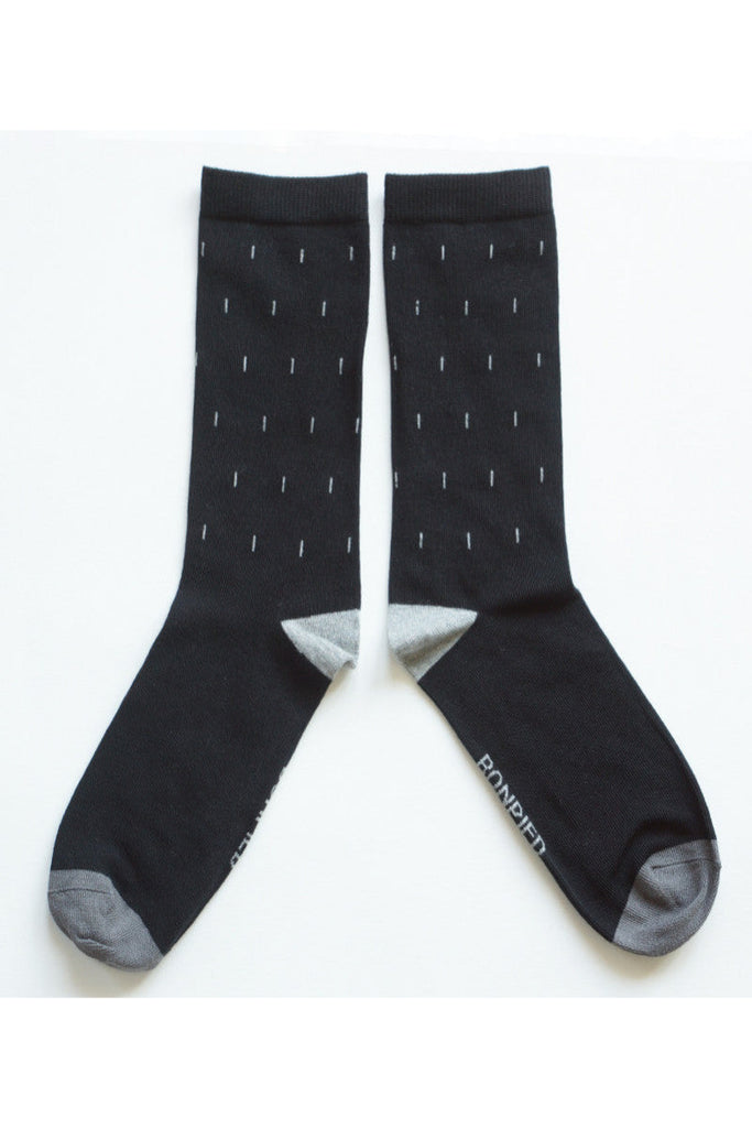 Pour chaque paire achetée, une paire est offerte à une personne sans abri. Ces mi-chaussettes pour homme, avec une tige de 25 cm, sont fabriquées en France, près de Limoges, par une entreprise labellisée Origine France Garantie et Entreprise du Patrimoine Vivant. Conçues avec une approche écoresponsable et solidaire, elles allient qualité, engagement social et respect de l’environnement.